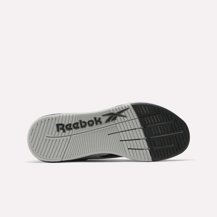 The image shows the sole of the Reebok Nano X5 Training Shoes, with a gray tread, black sections at the heel and toe, and a black Reebok logo with vector design printed across the center.