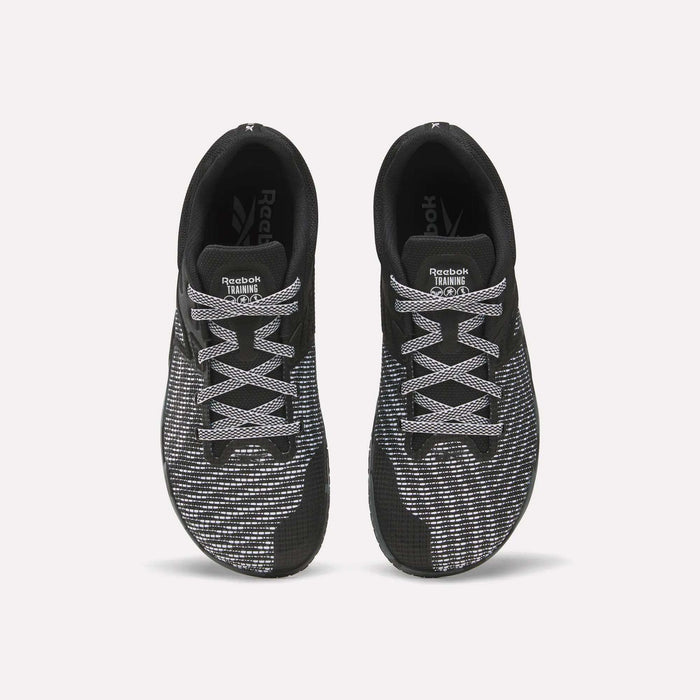 Top view of a pair of Reebok Nano Zero Training Shoes in black with white and gray patterned laces and mesh uppers, ideal for strength training, displayed side by side on a plain white background.