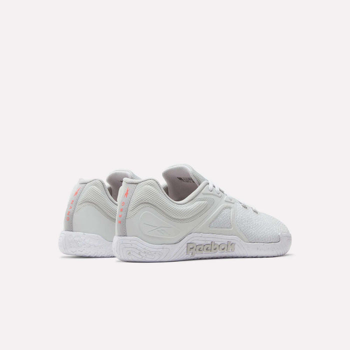 A pair of white Reebok Nano Zero Training Shoes with textured soles, mesh and synthetic details, and pink heel branding, shown from a rear side angle on a plain white background.