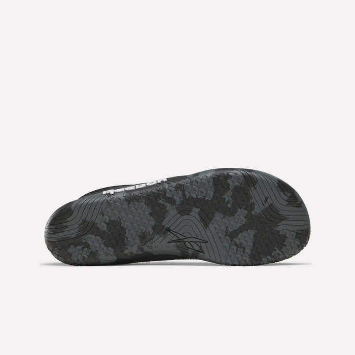 The image shows the black and gray camo outsole of Reebok Nano Zero Training Shoes, designed with textured grip and grooves to enhance traction and flexibility.