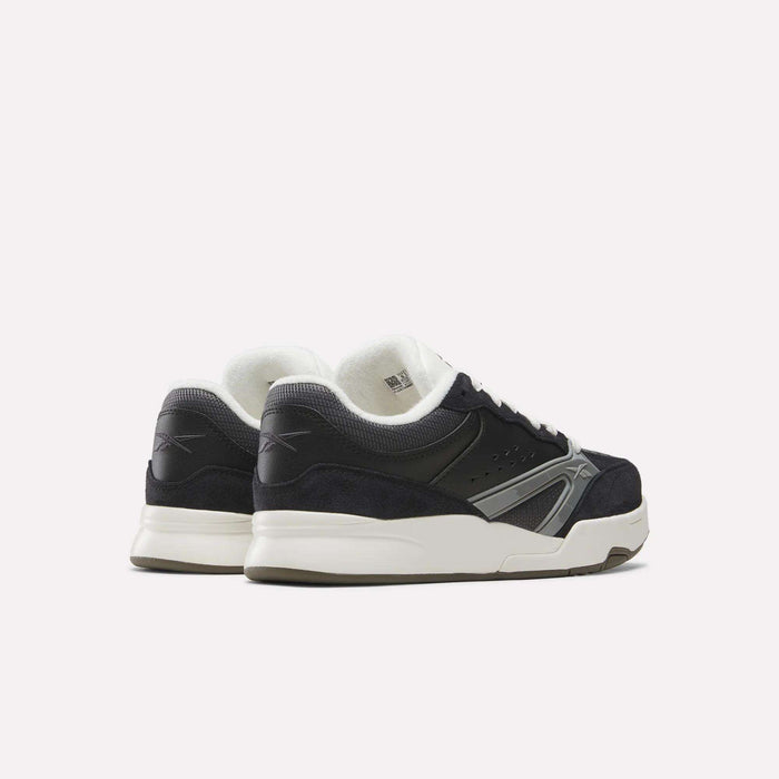 A pair of Reebok Omni Edge Shoes in black and white, designed with hoops-inspired style and crafted from premium materials, featuring white soles and shown from the back and side against a plain white background.