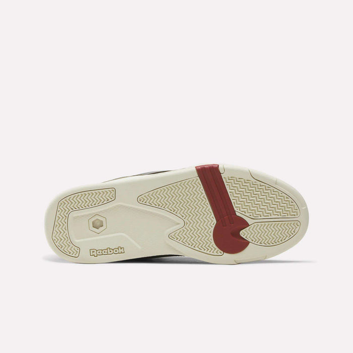 The outsole of the Reebok Omni Edge Shoes is displayed from beneath, featuring an off-white base accented with beige, red, and brown details. Its zigzag and geometric tread patterns draw inspiration from classic basketball court footwear, while the prominent Reebok logo underscores its standing in the premium sneaker category.