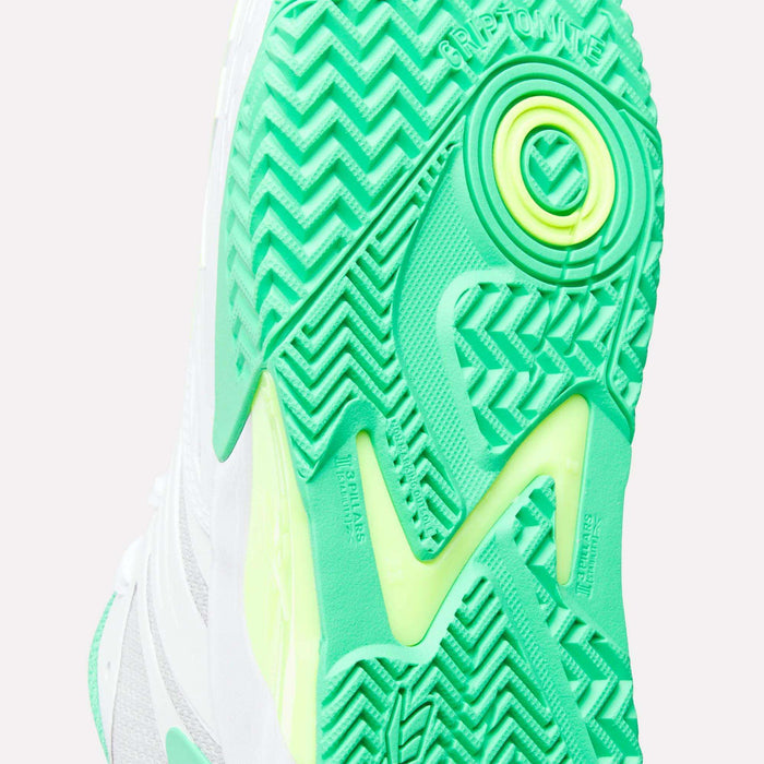 Close-up of the sole of Reebok Phase EVO Tennis Shoes, highlighting a bright green and yellow tread with zigzag and circular patterns. The word GRIPTONITE appears near the top, showcasing advanced grip technology.