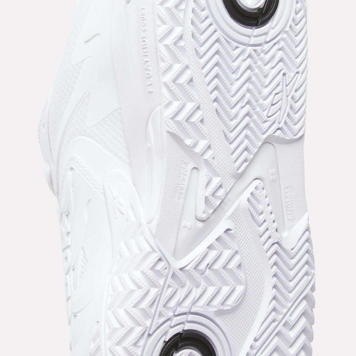 Close-up of the Reebok Phase EVO Tennis Shoes sole, showcasing detailed textured patterns, grooves with circular and zigzag designs, and embossed branding—highlighting the durable features of these tennis shoes.