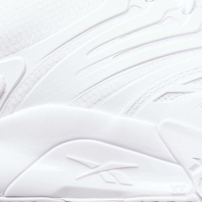 Close-up of a white Reebok Phase EVO Tennis Shoe, showcasing textured, layered materials and the embossed Reebok logo on the side. Smooth curves and raised patterns highlight its durable tennis shoe design.