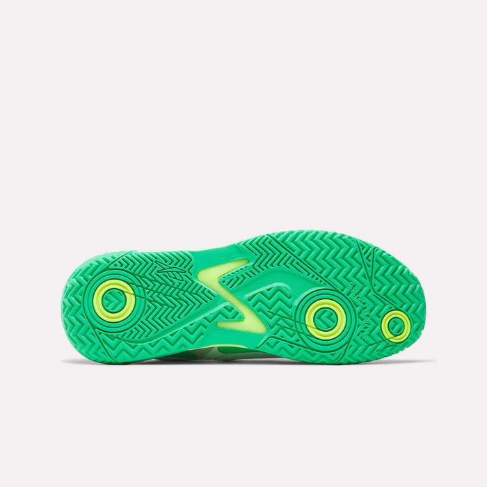 Bottom view of a vibrant green Reebok Phase EVO Tennis Shoes sole featuring yellow accents and unique zigzag and circular tread patterns on a plain white background, highlighting the durable tennis shoe design.