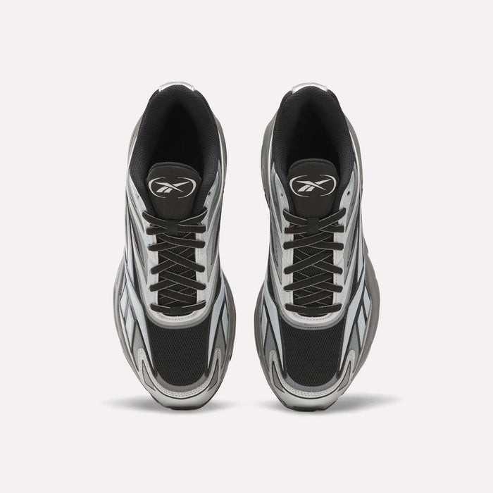 A pair of Reebok Premier Road 1000 Shoes in black, white, and gray are shown from above on a plain white background, featuring black laces and a stylized logo on each tongue—these retro athletic sneakers embody early 2000s design.
