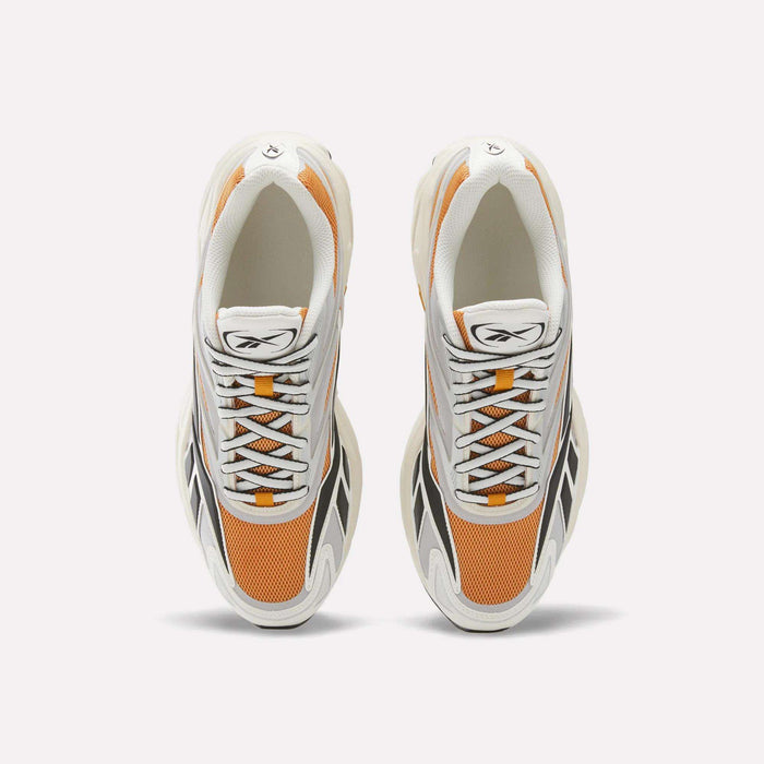 Top view of a pair of Reebok Premier Road 1000 Shoes, featuring white, orange, and black details with white laces, mesh panels, and an EVA midsole, placed side by side on a plain white background.