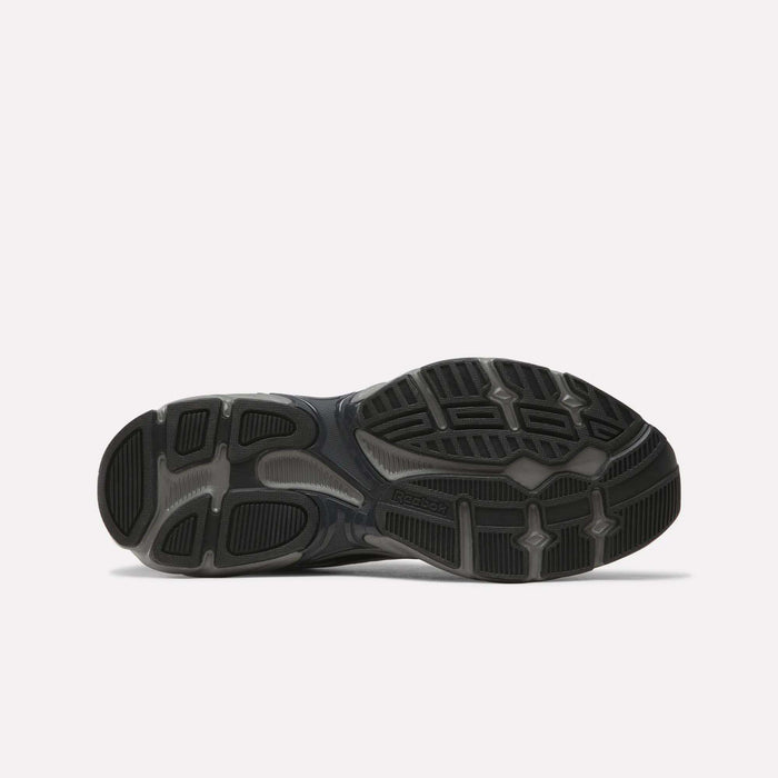 The image features the black and gray rubber sole of the Reebok Premier Road 1000 Shoes, viewed from below, highlighting its tread pattern and grip details against a plain white background—a signature element of classic retro running footwear.