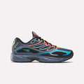 The Reebok Premier Road Control Shoes, shown in blue, black, and red with mesh material, wavy overlays, black laces, and a thick gray sole, are displayed in side profile against a white background.