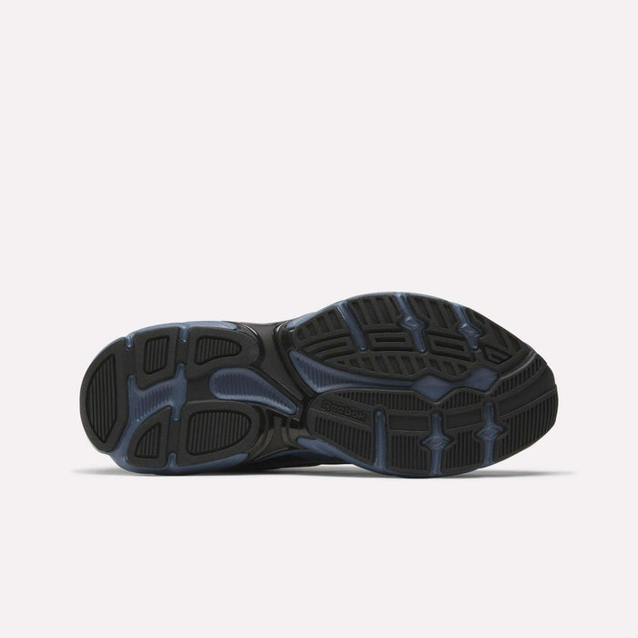 The image shows the black rubber outsole with textured tread and blue accents of Reebok Premier Road Control Shoes, photographed against a plain white background.