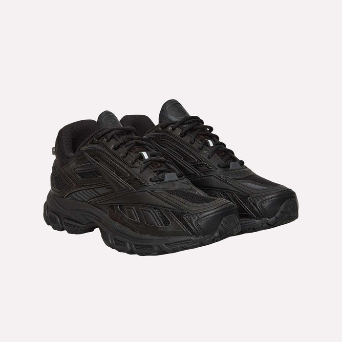 A pair of Reebok Premier Road Ultra LTD Shoes, featuring black athletic uppers with thick soles, mesh panels, and lace-up fronts inspired by archival running silhouettes, are displayed against a plain white background.