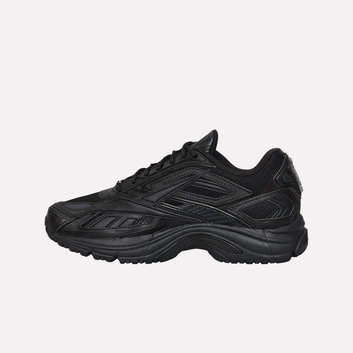 A black Reebok Premier Road Ultra LTD Shoe featuring a textured sole, dual-density midsole, and mesh detailing is shown in a side view against a plain white background—an archival running sneaker from Reebok reimagined for modern comfort and style.