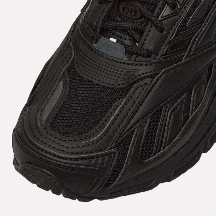 Close-up of the front and side of a black Reebok Premier Road Ultra LTD Shoe, highlighting detailed stitching, textured mesh, layered synthetic overlays, and a dual-density midsole for enhanced comfort.