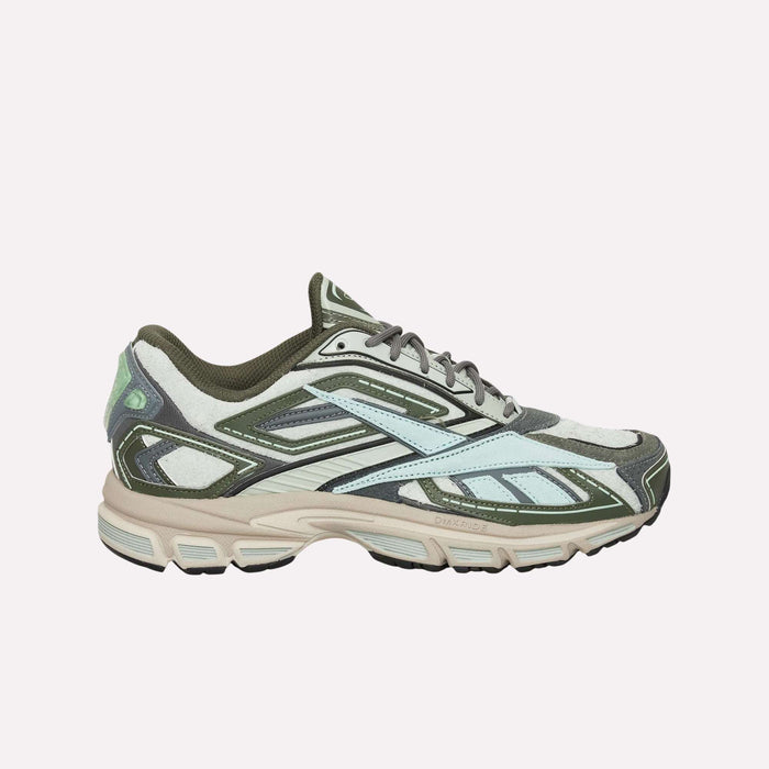 The Reebok Premier Road Ultra Shoes feature a layered design in light blue, olive green, beige, and white with a textured sole and dual-density midsole, showcased against a solid light blue background.