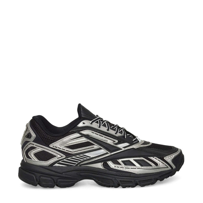 The Reebok Premier Road Ultra Shoes are displayed in a side profile against a white background, featuring a black and silver colorway with a mesh upper, intricate panel detailing, and a thick dual-density midsole for enhanced cushioning.