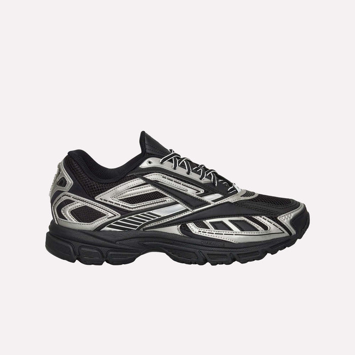 The Reebok Premier Road Ultra Shoes are displayed in side profile against a plain white background, featuring a black and silver design with a mesh upper, geometric patterns, and a thick textured sole with a dual-density midsole.