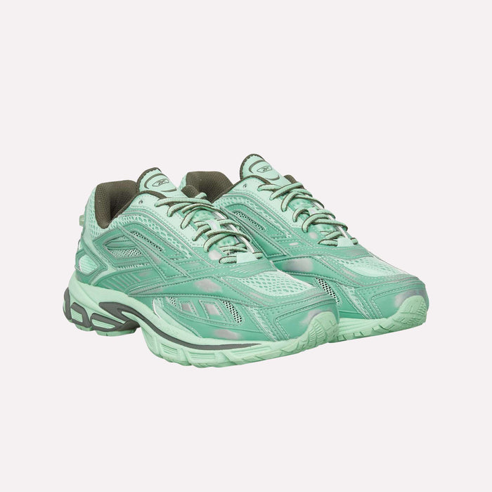 A pair of Reebok Premier Road Ultra Shoes in mint green, featuring mesh and synthetic uppers with gray accents and chunky soles that include a dual-density midsole, are positioned side by side on a plain white background. These archival sneakers combine classic Reebok style with modern comfort.