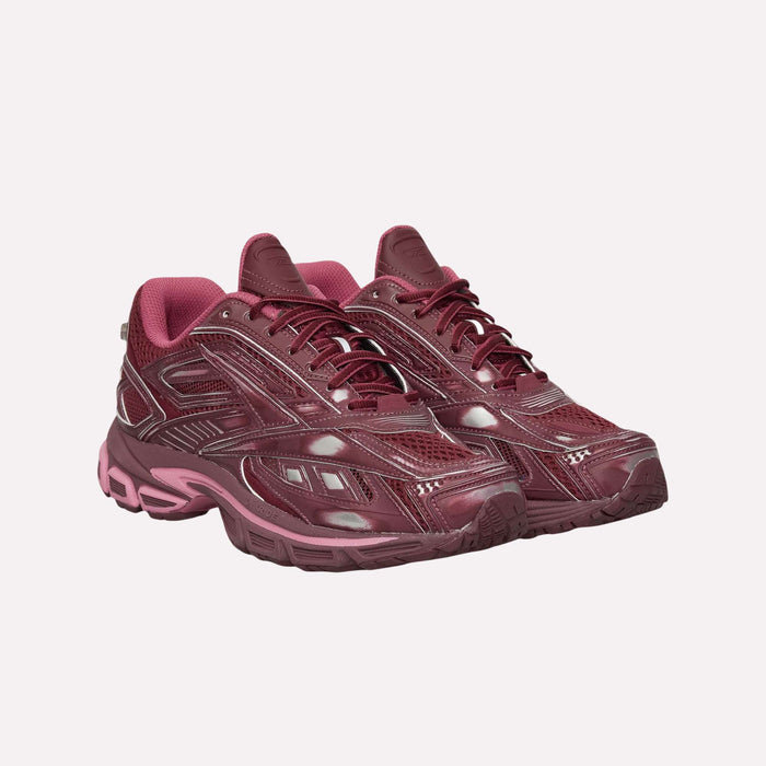 A pair of Reebok Premier Road Ultra Shoes in maroon, showcasing archival running style with a chunky sole, mesh panels, and glossy accents, equipped with a dual-density midsole for added comfort, positioned side by side on a plain light background.