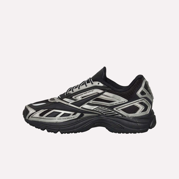 A black and silver Reebok Premier Road Ultra shoe featuring a breathable mesh upper, detailed overlays, and a thick textured sole with a dual-density midsole, displayed against a plain white background.