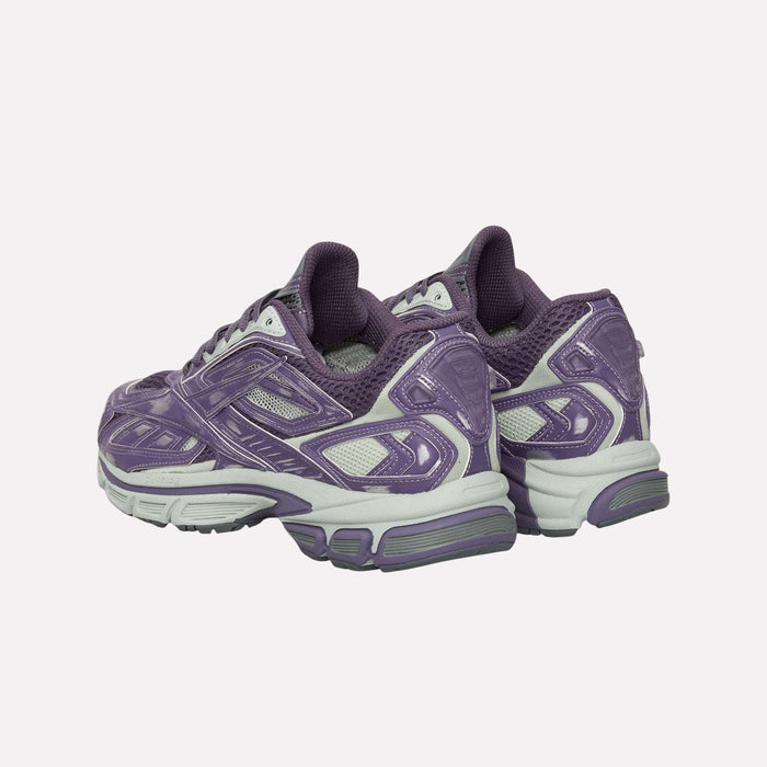A pair of Reebok Premier Road Ultra Shoes in purple and gray, showcasing mesh panels, textured soles, and a dual-density midsole, positioned at an angle against a plain light background.