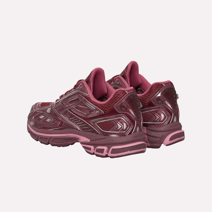 The Reebok Premier Road Ultra Shoes, featuring a maroon and pink colorway inspired by the brand’s archival running silhouette, are displayed on a plain white background with both the back and sides of the sneakers visible.