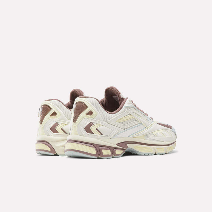 A pair of Reebok Premier Road Ultra SV Shoes in cream and mauve, featuring chunky Y2K-inspired soles, displayed at an angle to highlight both the side and heel details against a plain white background.