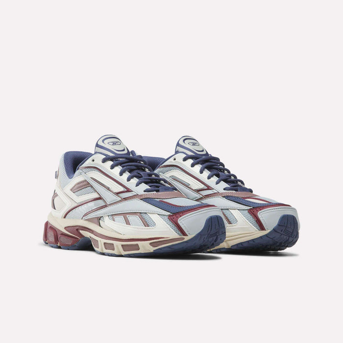 Introducing the Reebok Premier Road Ultra SV Shoes, a pair of athletic sneakers showcasing a blue, maroon, and white color scheme with mesh and synthetic panels, lace-up closures, and chunky soles inspired by classic Y2K designs.