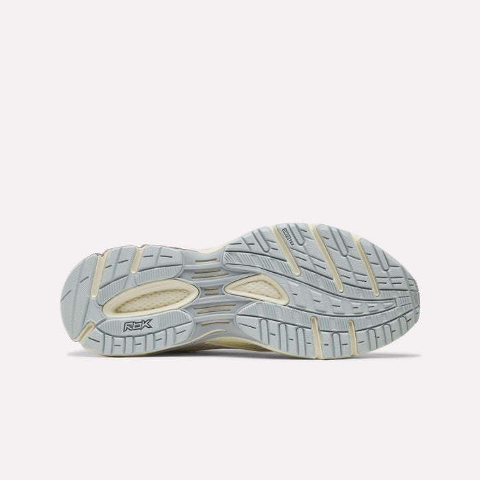 Grey and cream outsole featuring textured grip, grooves, and the Reebok RBK logo. Designed for the Reebok Premier Road Ultra SV Shoes, this sole showcases varied patterns for enhanced traction and support, displayed against a plain white background.