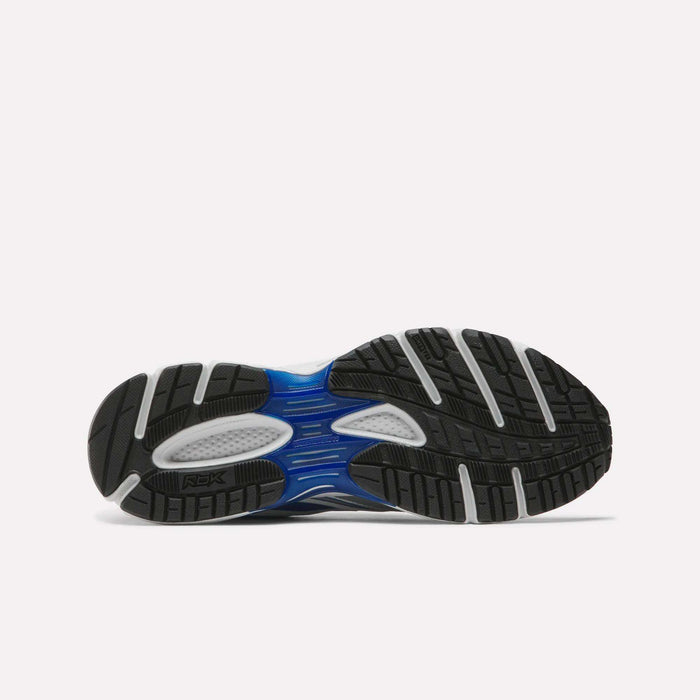 The image displays the black and gray rubber outsole of Reebok Premier Trinity Shoes, featuring blue and white accents and a tread pattern inspired by retro tech running shoes.