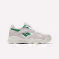 The Reebok Preseason 94 Low Retro Basketball Shoes feature a beige and white design with green accents, a chunky sole, and Reebok logos on the side and heel, inspired by '90s archive styles and shown against a plain white background.
