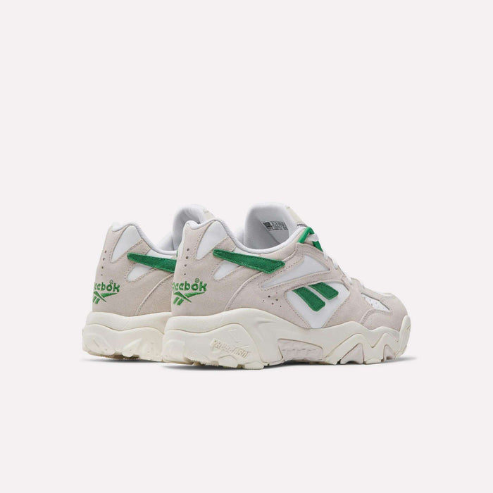 A pair of Reebok Preseason 94 Low Retro Basketball Shoes in light beige with green and white accents, viewed from the back and side, featuring the Reebok logo and chunky off-white soles inspired by '90s training styles.