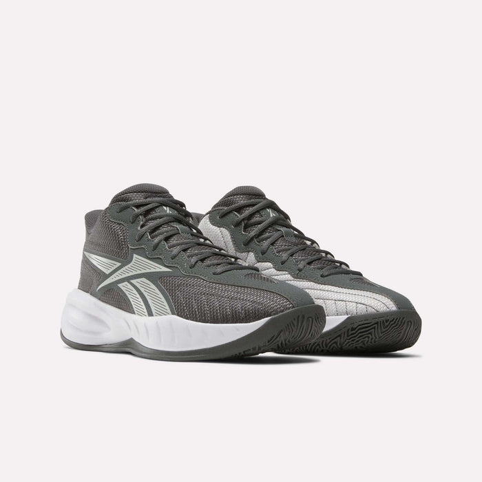 The Reebok Press Basketball Shoes are gray athletic sneakers with white accents and thick white soles. Inspired by basketball heritage, they feature a mesh texture, lace-up design, and comfortable EVA cushioning against a plain background.