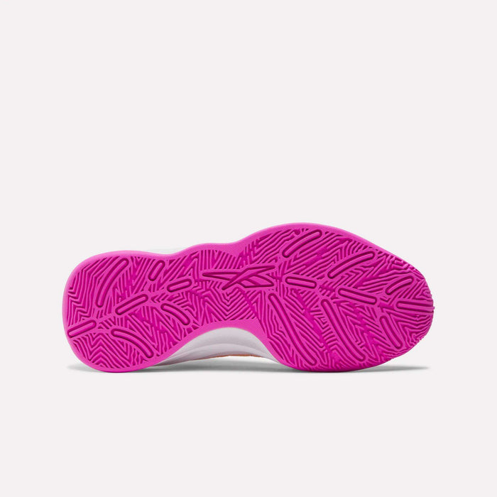 The image shows the sole of Reebok Press Basketball Shoes, featuring a bright pink, textured rubber outsole with a geometric herringbone pattern and EVA cushioning, photographed against a plain white background.