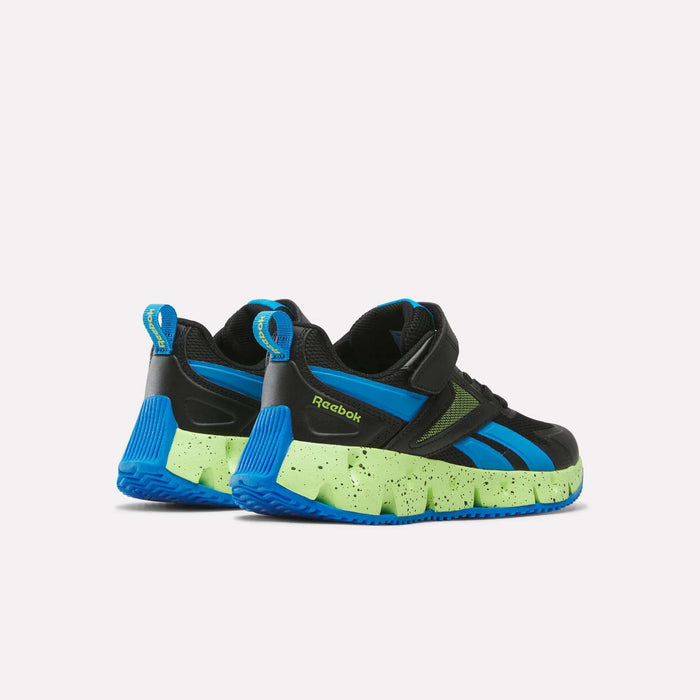 A pair of Reebok Pyro Storm 1V Shoes - Little Kids are displayed from the back and side, featuring black uppers, blue accents, and speckled neon green soles against a plain white background. These athletic shoes for kids include a durable rubber outsole designed for long-lasting wear and reliable traction.