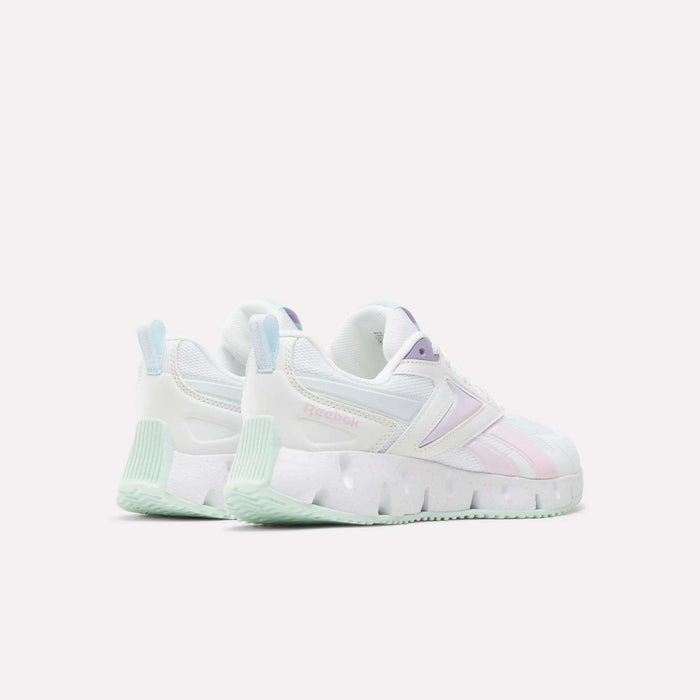 The Reebok Pyro Storm Shoes for big kids, featuring a white design with pastel pink and purple accents, chunky soles, and mint green details, are displayed against a plain light background.