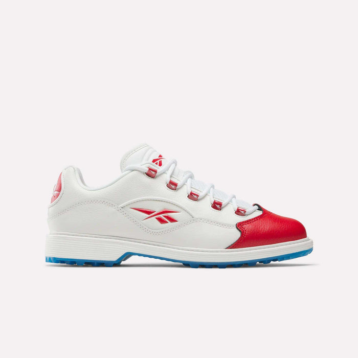The Reebok Question Golf Shoes are premium white athletic sneakers with red accents including a red toe cap and logo, blue outsole, and white laces. Shown in a modern side view on a plain light background for a spikeless golf look.