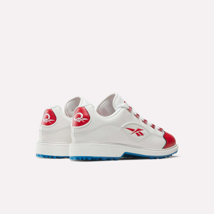 The Reebok Question Golf Shoes feature a white design with red accents, blue soles, and Reebok logos on the side and heel. Styled like premium golf shoes, they're shown angled on a plain white background.