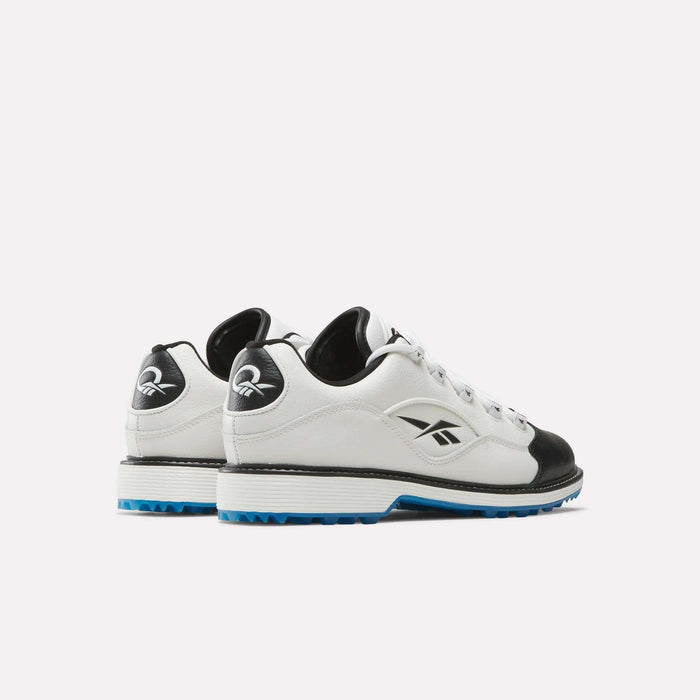 A pair of Reebok Question Golf Shoes in white and black with blue soles, shown from an angled rear side. Made from full grain leather, they feature the Reebok logo on the sides and heels for a premium look.