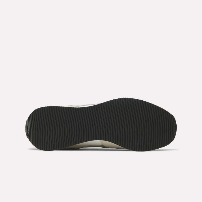 The image shows the black, ribbed outsole of Reebok R100 Shoes viewed from below on a white background, evoking classic '70s running style.