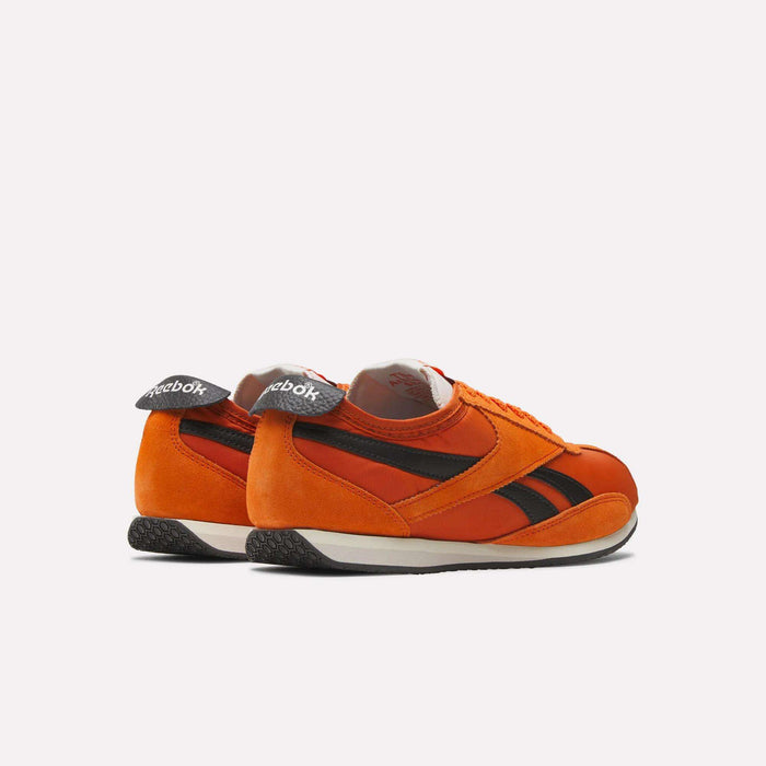 The Reebok R400 Shoes are retro track sneakers in orange with black stripes, white midsoles, and black textured outsoles, shown from the back and side against a plain light background.