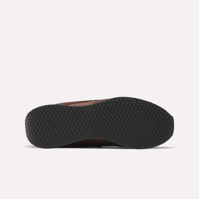 The image displays the bottom of a black Reebok R400 shoe sole with a textured circular grip pattern, inspired by classic retro track spike designs, set against a plain white background.