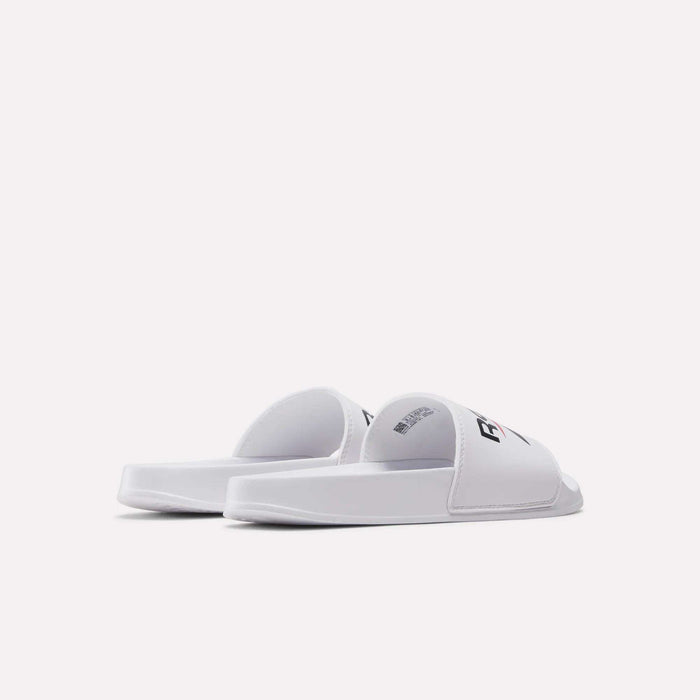 A pair of RBK Fulgere Swim Slides by Reebok, featuring a white slip-on style with thick soles and open-toe design, displayed from a rear side angle on a plain white background.