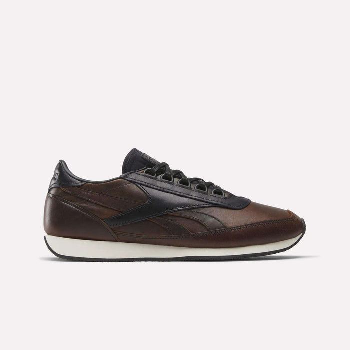 The Reebok Camargue x C.F. Stead Shoes, shown in side profile on a plain white background, feature brown full-grain leather with black accents and laces, a dark navy heel and sole detail, plus a white midsole in archival style.