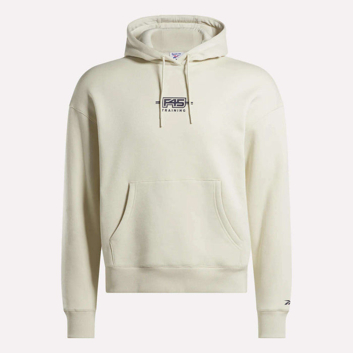 The Reebok x F45 Training Relaxed Fleece Hoodie by Reebok features a cream-colored fleece, relaxed fit, front pocket, black F45 Training logo on the chest, and a small logo on the left sleeve near the wrist.