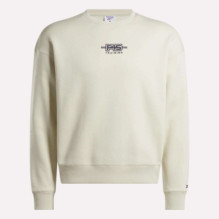The Reebok x F45 Training Relaxed Graphic Sweatshirt features a cream color, dark F45 TRAINING and barbell logo on the chest, long sleeves, and a relaxed fit—ideal for post-workout lounging.