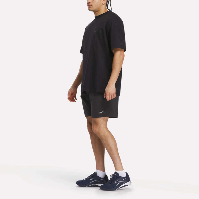 Someone stands against a plain white background, partially out of view, sporting a Reebok x F45 Training Relaxed T-Shirt—a casual style from Reebok perfect for F45 Training sessions or laid-back everyday wear.