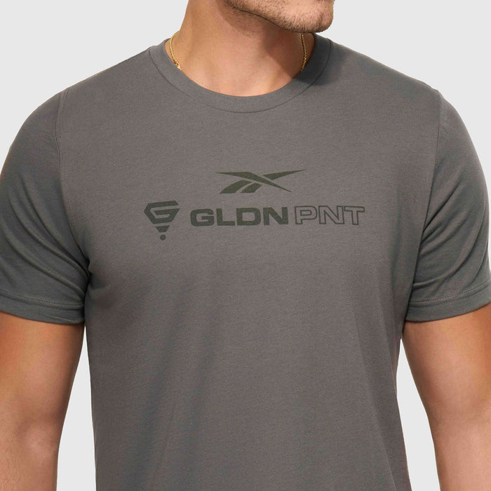 A person models the Reebok x GLDN PNT Jersey Tee, featuring “GLDN PNT” and two logos on the chest, shown from shoulders to waist against a plain background.