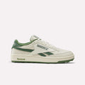 The Reebok x Manors Club C Revenge Golf Shoes showcase a Vintage Chalk, Legacy Green, and Linen colorway with distinctive Manors branding. This classic low-top silhouette features green accents on the sole, laces, and heel, all expertly presented against a clean white background.