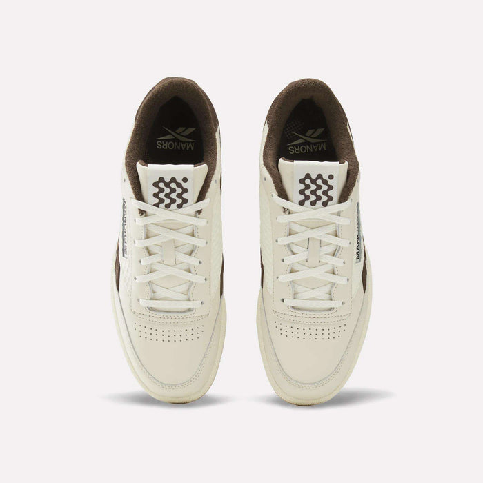 A pair of cream and brown Reebok x Manors Club C Revenge Golf Shoes viewed from above, featuring white laces, perforated toes, and the Reebok brand name on the tongue and side.